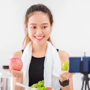 beautiful-asian-woman-healthy-blogger-is-showing-apple-fruit-clean-diet-food-front-smartphone-recording-vlog-video-live-streaming-home-fitness-influencer-social-media-online_7191-1592